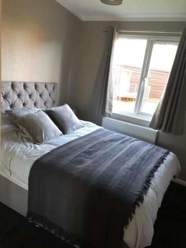 a bedroom with a large bed with a window at Spacious Lodge With Hot Tub in Lincolnshire