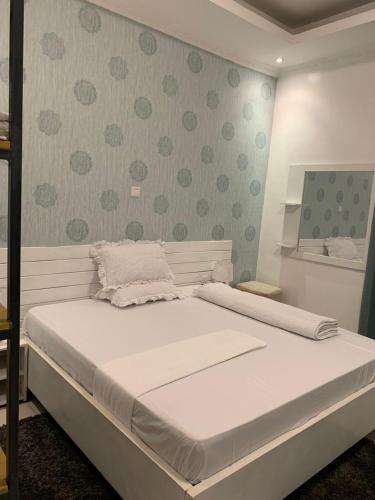 een groot wit bed in een kamer met stippen bij Bella Vida Hotel apartment in Kigali