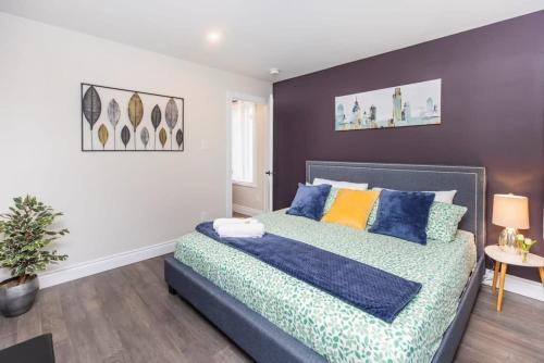 a bedroom with a bed with blue and yellow pillows at Pet-Friendly 2BR Condo - Near University in Ottawa