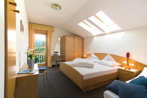 a hotel room with a bed and a window at Hotel Schönbrunn in Schenna