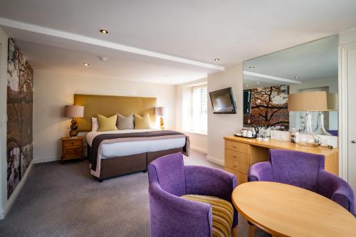 a hotel room with a bed and a table and chairs at Ambleside Townhouse in Ambleside