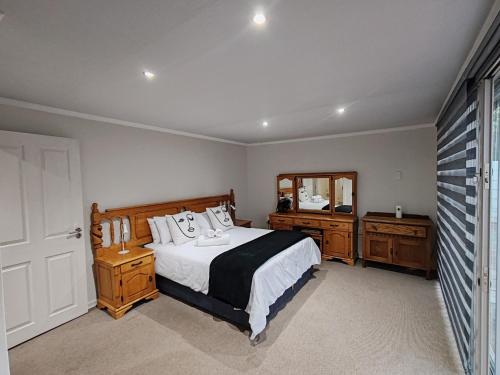 a bedroom with a bed and two dressers and a mirror at 2 Bedroom Private Retreat in Bloemfontein