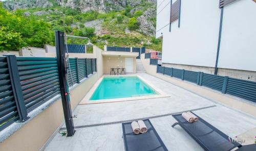 una piscina con due sedie a sdraio accanto a un edificio di Apartments Gallery M and A - with pool a Mostar