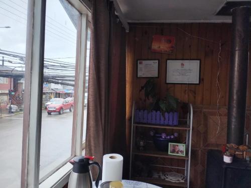 a corner of a room with a window and a table at QUELKUN, FAMILIAR in Quellón