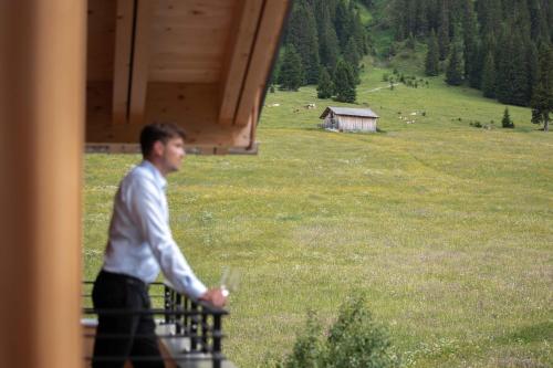 Un uomo che cammina in un campo con un portatile di Die Lecherin a Lech am Arlberg