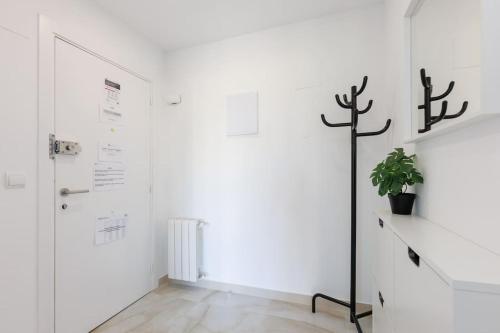 a white hallway with a door and a potted plant at Housalia Casa del Mar en Vila Olímpica in Barcelona
