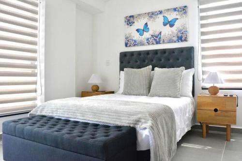 Schlafzimmer mit einem blauen Bett und einem blauen getufteten Kopfteil in der Unterkunft Casa Campestre con Piscina Cerca al Parque del Café in La Tebaida
