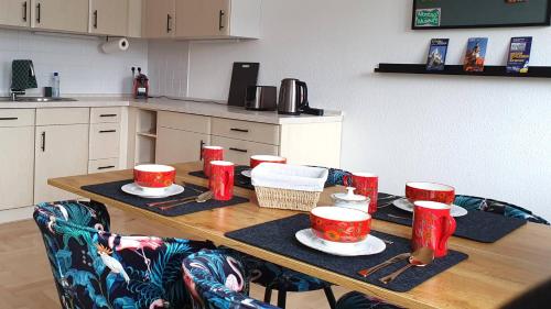 a kitchen table with red cups and plates on it at Kienreich Apartments Görlitzer Innenstadt in Görlitz