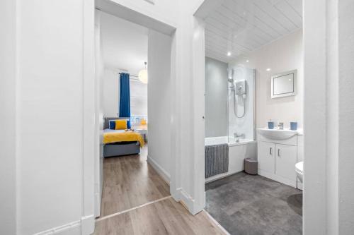 een witte badkamer met een bad en een wastafel bij Townhead in Kirkintilloch