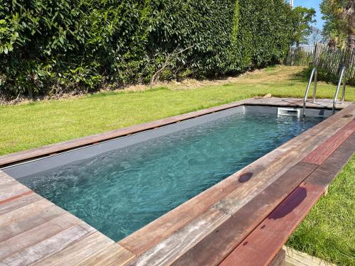 a swimming pool in a yard with a wooden deck at Kartier chambre deluxe in Plouguenast