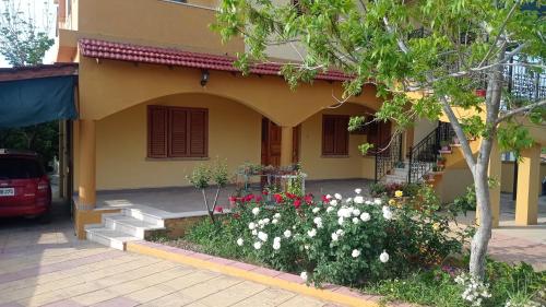 a house with a flower garden in front of it at Kaplıca Köyünde Tam Müstakil Tatil Evi in Dhavlos
