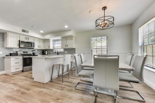 a kitchen with white cabinets and a table and chairs at Walk to Trout River Pier Modern Home with Yard in Jacksonville