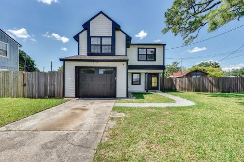 a white house with a garage in a yard at Walk to Trout River Pier Modern Home with Yard in Jacksonville