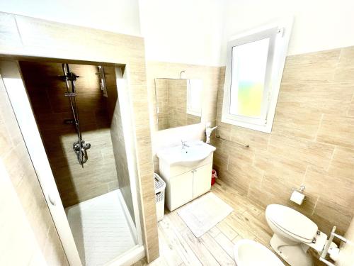 un bagno con un water, un lavandino e uno specchio di Villa vista mare con giardino e parcheggio a Nardò