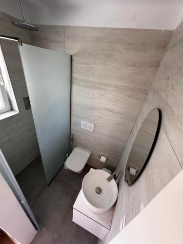 a bathroom with a white toilet and a mirror at Panorama Hideaway in Dassia