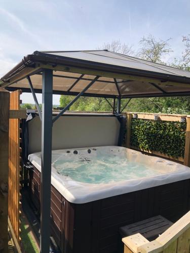 a hot tub under a gazebo at Spacious Lodge With Hot Tub in Lincolnshire