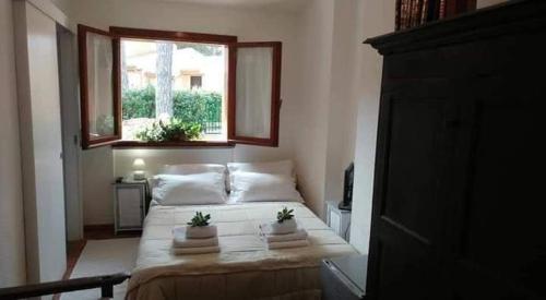 una camera da letto con un letto con due piante sopra di Casa Helichrysum a Santa Margherita di Pula