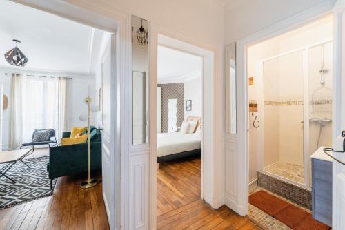 Cette chambre blanche comprend un lit et une salle de bains. dans l'établissement BAIL MOBILITE APPARTEMENT COSY PARIS - BUTTES CHAUMONT, à Paris