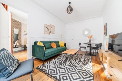 un salon avec un canapé vert et une table dans l'établissement BAIL MOBILITE APPARTEMENT COSY PARIS - BUTTES CHAUMONT, à Paris