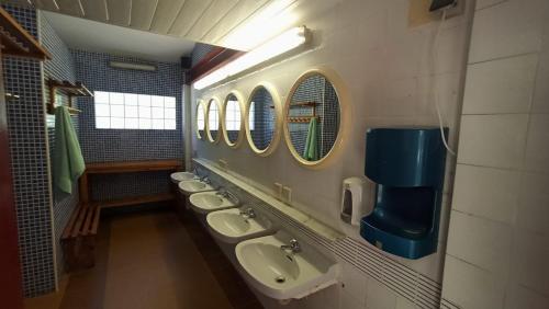 a bathroom with a row of sinks and mirrors at Camping Collegats in La Pobla de Segur