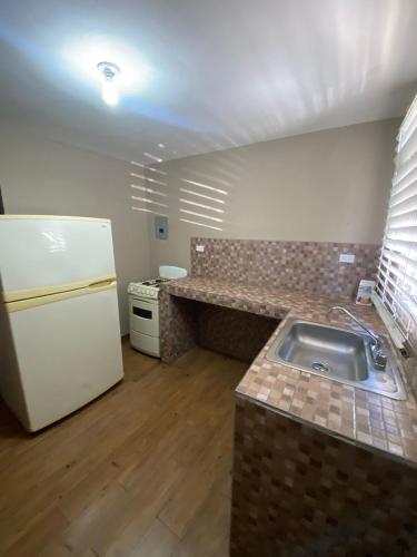 a kitchen with a sink and a refrigerator at Departamento en ciudad Tipo Campirano in Mexicali