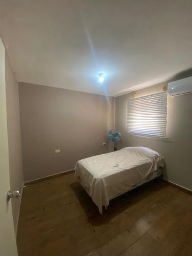 1 dormitorio con 1 cama con luz en el techo en Departamento en ciudad Tipo Campirano, en Mexicali