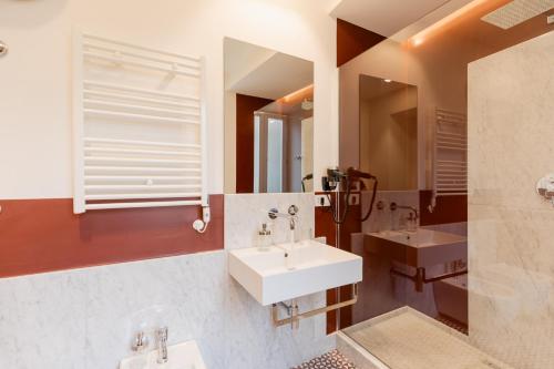 a bathroom with two sinks and a mirror at Piazza San Domenico Luxury Suites in Naples