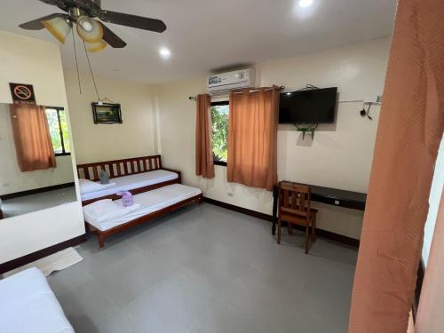 a room with two beds and a flat screen tv at Adayo Cove Resort in Siquijor