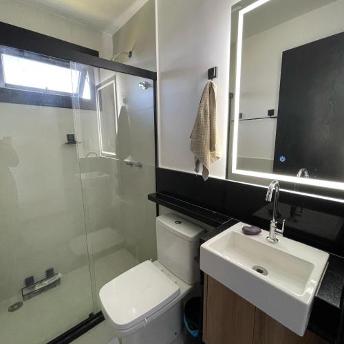 a bathroom with a toilet and a sink and a shower at Mykonos Praia do Forte in Praia do Forte