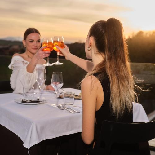 two women sitting at a table with glasses of wine at Terra di Gradara in Gradara