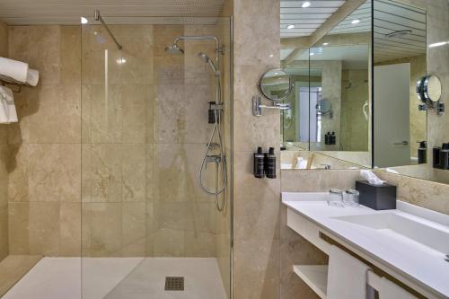 een badkamer met een douche, een wastafel en een spiegel bij Eurostars Don Cándido in Terrassa