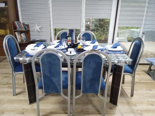 a dining room table with blue chairs around it at Krčma u Planini in Bojnik