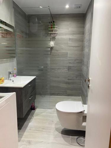 a bathroom with a toilet and a glass shower at Sea View Apartment in Sarandë