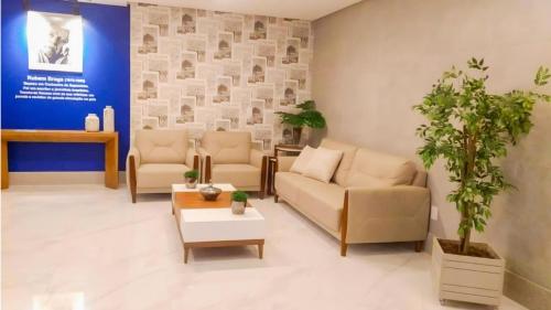 a waiting room with couches and a potted plant at Magnifico apto com vista para o mar!!!! in Guarapari