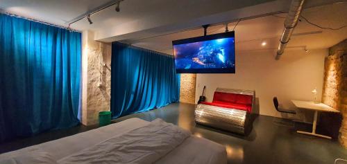 a bedroom with a bed and a flat screen tv at Loft im Szeneviertel Mannheims in Mannheim