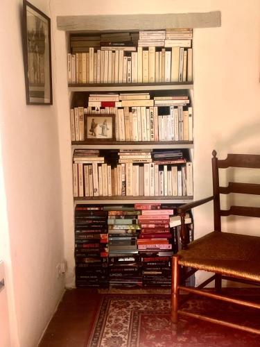 une étagère remplie de livres à côté d'une chaise dans l'établissement lamaisondartistes, à Gargas