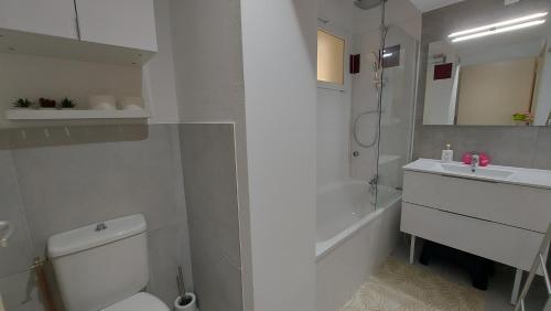a white bathroom with a toilet and a sink at T2, 50m du lac, PISCINE, WIFI, jardin terrasse sans vis-à-vis, 1 à 4 pers in Aureilhan