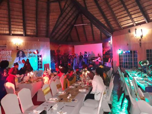 a group of people sitting at tables in a room at The Big Five Lodge in Gaborone