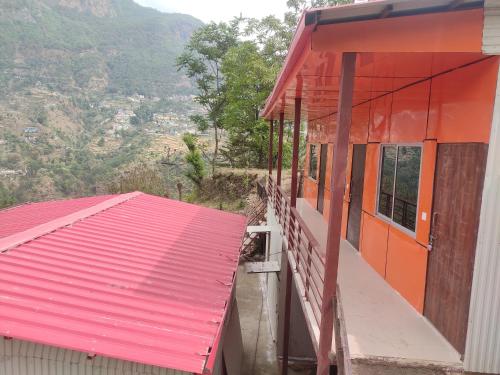 un edificio con techo rojo y techo rojo en Hilans Hotel and Restaurant en Ukhimath