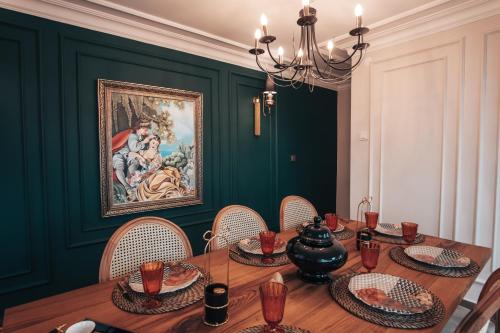 a dining room with a table with chairs and a painting at Samsun Charme Hotel in Samsun