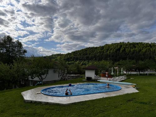 eine Gruppe von Personen in einem Schwimmbad auf einem Feld in der Unterkunft Guest House By The River in Stevrek