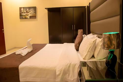 أجنحة منازل معالي في الرياض: غرفة نوم مع سرير أبيض كبير مع اللوح الأمامي الأسود