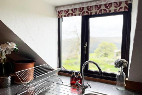 um lavatório de cozinha com uma janela numa cozinha em Kiri and Norton - joint booking em Dulverton
