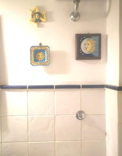 a bathroom with two clocks on the wall at B&B PARNASO in Torre Annunziata