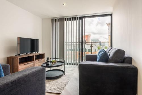 a living room with a couch and a flat screen tv at Lovely 1 Bedroom Apartment in Central Sheffield in Sheffield