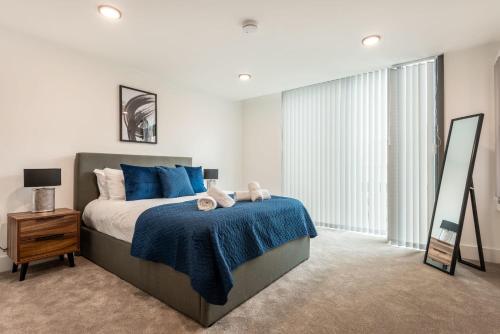 a bedroom with a bed with blue pillows and a mirror at Lovely 1 Bedroom Apartment in Central Sheffield in Sheffield