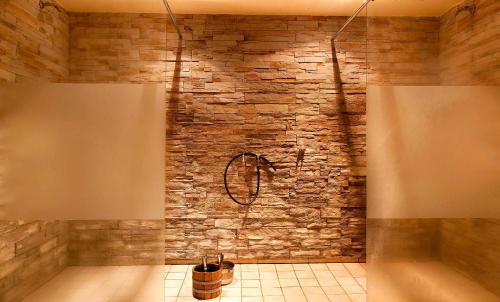 a bathroom with a stone wall and a tub at Hotel Riesberghof in Lindberg