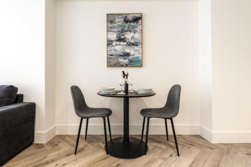 a table and two chairs in a room with a couch at Lovely 1 Bedroom Apartment in Central Sheffield in Sheffield