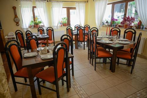 jadalnia ze stołami, krzesłami i oknami w obiekcie Pensiunea Anotimpuri w mieście Predeal