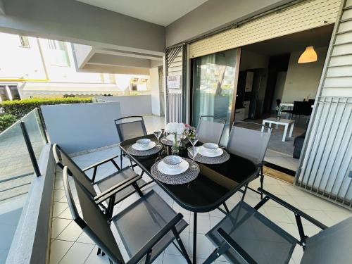 a black dining table and chairs on a balcony at Appartamenti Carinzia - Flexrent Immobiliare Abissinia in Riccione